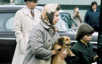 Queen Elizabeth II , accompanied by Lady Sarah Armstrong-Jones, carries one of her pet dogs at Windsor Great Park on May 01, 1977.