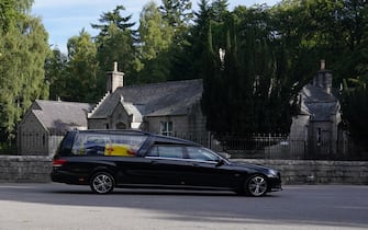 The hearse carrying the coffin of Queen Elizabeth II, draped with the Royal Standard of Scotland, leaving Balmoral as it begins its journey to Edinburgh. Picture date: Sunday September 11, 2022.