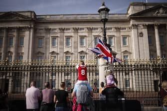 epa10177313 A child waves the Union Flag in front of Buckingham Palace as they pay their respects to Queen Elizabeth II in London, Britain, 11 September 2022. Britain's Queen Elizabeth II died at her Scottish estate on 08 September.  The 96-year-old queen was the longest-reigning monarch in British history.  EPA / YOAN VALAT