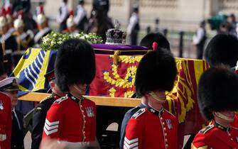 The coffin of Queen Elizabeth II, draped in the Royal Standard with the Imperial State Crown placed on top, is carried on a horse-drawn gun carriage of the King's Troop Royal Horse Artillery, during the ceremonial procession from Buckingham Palace to Westminster Hall, London , where it will lie in state ahead of her funeral on Monday.  Picture date: Wednesday September 14, 2022.