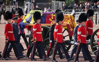 The coffin of Queen Elizabeth II, draped in the Royal Standard with the Imperial State Crown placed on top, is carried on a horse-drawn gun carriage of the King's Troop Royal Horse Artillery surrounded by members of the Grenadier Guards, during the ceremonial procession from Buckingham Palace to Westminster Hall, London, where it will lie in state ahead of her funeral on Monday. Picture date: Wednesday September 14, 2022.