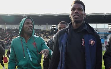 In this photograph taken on December 29, 2019 France national team player Paul Pogba (C) and his brother Mathias Pogba (L) walk on the pitch prior to a football match between All Star France and Guinea at the Vallee du Cher Stadium in Tours, central France, as part of the "48h for Guinea" charity event. (Photo by GUILLAUME SOUVANT / AFP) (Photo by GUILLAUME SOUVANT/AFP via Getty Images)
