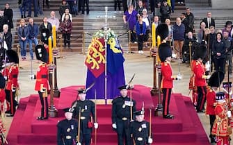 LONDON, ENGLAND - SEPTEMBER 15:  Members of the public file past the coffin of Queen Elizabeth II, draped in the Royal Standard with the Imperial State Crown and the Sovereign's orb and sceptre, lying in state on the catafalque in Westminster Hall, at the Palace of Westminster, ahead of her funeral on Monday, on September 15, 2022 in London, England. Members of the public are able to pay respects to Her Majesty Queen Elizabeth II for 23 hours a day until 06:30 on September 19, 2022.  Queen Elizabeth II died at Balmoral Castle in Scotland on September 8, 2022, and is succeeded by her eldest son, King Charles III. (Photo by Yui Mok - WPA Pool/Getty Images)