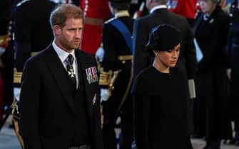 LONDON, ENGLAND - SEPTEMBER 14: Prince Harry, Duke of Sussex and Meghan, Duchess of Sussex pay their respects at The Palace of Westminster during the procession for the Lying-in State of Queen Elizabeth II on September 14, 2022 in London, England. Queen Elizabeth II's coffin is taken in procession on a Gun Carriage of The King's Troop Royal Horse Artillery from Buckingham Palace to Westminster Hall where she will lay in state until the early morning of her funeral. Queen Elizabeth II died at Balmoral Castle in Scotland on September 8, 2022, and is succeeded by her eldest son, King Charles III. (Photo by Alkis Konstantinidis-WPA Pool/Getty Images)