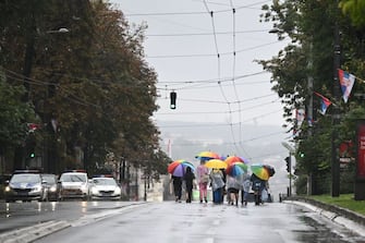 LGBT Activists hold a rainbow umbrella as they march during a pride march, in Belgrade, on September 17, 2022. - The situation was tense on September 17, 2022, in Belgrade where representatives of the LGBTQ community vowed to march despite a ban on a Europride march by the authorities, raising fears of potential unrest. (Photo by ANDREJ ISAKOVIC / AFP) (Photo by ANDREJ ISAKOVIC/AFP via Getty Images)