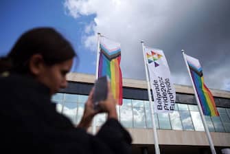 A woman take a photo using her mobile phone of the EuroPride flags fluttering during the opening ceremony of the EuroPride 2022 in Belgrade on September 12, 2022. - Last month, Serbian President Aleksandar Vucic said he had decided to "postpone or cancel" the Europride gathering, citing a litany of reasons, including recent tensions with the former breakaway province Kosovo and concerns over energy and food.EuroPride organisers slammed the move, saying the government had no authority to cancel the event. (Photo by OLIVER BUNIC / AFP) (Photo by OLIVER BUNIC/AFP via Getty Images)
