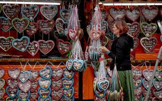 epa10189299 A shop owner arranges gingerbread hearts for sale during the opening of the 187th edition of the traditional Oktoberfest beer and amusement festival in the Bavarian state capital of Munich, Germany, 17 September 2022. The Oktoberfest 2022 runs from 17 September to 03 October and several millions of visitors are expected from all over the world. The event resumes after being canceled for two years in a row due to the coronavirus pandemic.  EPA/CHRISTIAN BRUNA