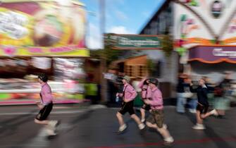 epa10189294 A photo taken using a slow shutter speed shows visitors running during the opening of the 187th edition of the traditional Oktoberfest beer and amusement festival in the Bavarian state capital of Munich, Germany, 17 September 2022. The Oktoberfest 2022 runs from 17 September to 03 October and several millions of visitors are expected from all over the world. The event resumes after being canceled for two years in a row due to the coronavirus pandemic.  EPA/CHRISTIAN BRUNA