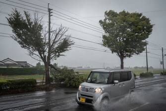 A car passes a fallen tree as Typhoon Nanmadol approaches in Izumi, Kagoshima prefecture on September 18, 2022. (Photo by Yuichi YAMAZAKI / AFP) (Photo by YUICHI YAMAZAKI / AFP via Getty Images)