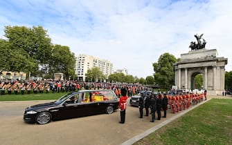 LONDON, ENGLAND - SEPTEMBER 19: The Royal Hearse carrying the coffin of Queen Elizabeth II at Wellington Arch on September 19, 2022 in London, England. Elizabeth Alexandra Mary Windsor was born in Bruton Street, Mayfair, London on 21 April 1926. She married Prince Philip in 1947 and ascended the throne of the United Kingdom and Commonwealth on 6 February 1952 after the death of her Father, King George VI. Queen Elizabeth II died at Balmoral Castle in Scotland on September 8, 2022, and is succeeded by her eldest son, King Charles III.  (Photo by David Ramos/Getty Images)
