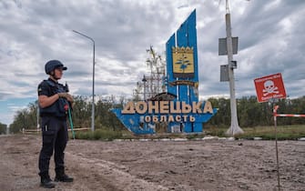 epa10195513 A Ukrainian sapper stands in front of the stele reading 'Donetsk Oblast' on a symbolic border between the Kharkiv and Donetsk areas and next to a sign that reads 'Danger mines', Ukraine, 20 September 2022 amid Russia's military invasion. The Ukrainian army pushed Russian troops from occupied territory in the northeast of the country in a counterattack. Kharkiv and surrounding areas have been the target of heavy shelling since February 2022, when Russian troops entered Ukraine starting a conflict that has provoked destruction and a humanitarian crisis.  Leaders of the Russian backed self-proclaimed Donetsk People's Republic (DPR), self-proclaimed Luhansk People's Republic (LPR) and the region of Kherson announced on 20 Septembers, plans to hold a referendum for their territories to join the Russian Federation.  EPA/YEVGEN HONCHARENKO