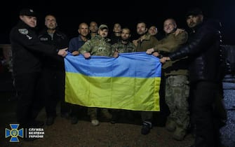 epa10198536 A handout photo made available by the Press Service of the Security Service of Ukraine (SBU) on 22 September 2022 shows a group of Ukrainian prisoners of war (POW) holding a Ukrainian flag after their exchange, in the Chernihiv region, Ukraine. Ukraine has returned 215 prisoners from Russian captivity, including Mariupol's Azovstal steel plant fighters, who spent months defending the steel plant and surrendered in May during the Russian siege, according to Ukraine's Presidential Administration.  EPA/SECURITY SERVICE OF UKRAINE HANDOUT -- MANDATORY CREDIT: SECURITY SERVICE OF UKRAINE -- HANDOUT EDITORIAL USE ONLY/NO SALES