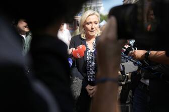 1422787715 HENIN-BEAUMONT, FRANCE - SEPTEMBER 11: French far-right party "National Rally" (Rassemblement Naional) leader Marine Le Pen talks with journalists as she visits flea market on September 11, 2022 in Henin-Beaumont, France. (Photo by Sylvain Lefevre/Getty Images)
