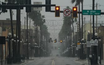 TOPSHOT - Wind and rain pick up in the Ybor City neighborhood ahead of Hurricane Ian making landfall on September 28, 2022 in Tampa, Florida. - Ian intensified to just shy of catastrophic Category 5 strength Wednesday as its heavy winds began pummelling Florida, with forecasters warning of life-threatening storm surges after leaving millions without power in Cuba. (Photo by Bryan R. Smith / AFP) (Photo by BRYAN R. SMITH/AFP via Getty Images)