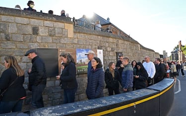 Members of the public and tourists queue to visit Windsor Castle in Windsor, west of London on September 29, 2022, as the Castle re-opened to visitors following the death of Queen Elizabeth II. - Windsor Castle reopened to the public Thursday, with visitors able to visit St George's Chapel, where an inscribed stone slab marking the death of Queen Elizabeth II has been laid in the King George VI Memorial Chapel inside the Castle. (Photo by Glyn KIRK / AFP) (Photo by GLYN KIRK/AFP via Getty Images)