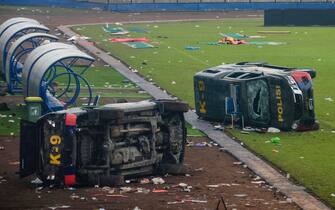 epa10218863 Damaged police vehicles lay on the pitch inside Kanjuruhan stadium in Malang, East Java, Indonesia, 02 October 2022. At least 127 people including police officers were killed mostly in stampedes after a clash between fans of two Indonesian soccer teams, according to the police.  EPA/SANDI SADEWA