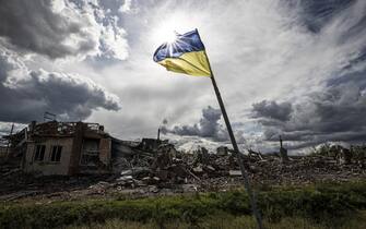 DOLINA, DONETSK, UKRAINE - SEPTEMBER 24: Ukrainian flag waves in a residential area heavily damaged in the village of Dolyna in Donetsk Oblast, Ukraine after the withdrawal of Russian troops on September 24, 2022. Many houses and St. George's Monastery were destroyed in the Russian attacks. Ukraine said on Saturday that its soldiers were entering the city of Lyman in the eastern region of Donetsk, which Russia had annexed a day earlier. (Photo by Metin Aktas/Anadolu Agency via Getty Images)
