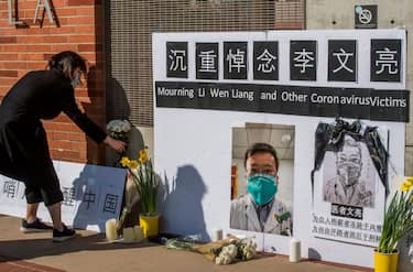 Chinese students and their supporters hold a memorial for Dr Li Wenliang, who was the whistleblower of the Coronavirus, Covid-19, that originated in Wuhan, China and caused the doctors death in that city, outside the UCLA campus in Westwood, California, on February 15, 2020. - The death toll from the new coronavirus outbreak surpassed 1,600 in China on Sunday, with the first fatality reported outside Asia fuelling global concerns. (Photo by Mark RALSTON / AFP) (Photo by MARK RALSTON/AFP via Getty Images)