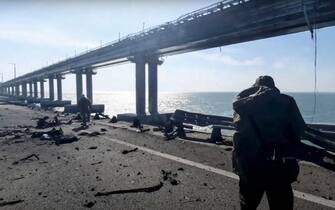 epa10230386 A still image taken from handout video provided by the Russian Investigative committee shows Russian investigators work on a collapsed part of the Kerch Strait bridge in Crimea, 08 October 2022. According to Russian authorities, "an explosion was set off at a cargo vehicle on the motorway part of the Crimean bridge on the side of the Taman peninsula, which set fire to seven fuel tanks of a train that was en route to the Crimean peninsula. Two motorway sections of the bridge partially collapsed."  EPA/RUSSIAN INVESTIGATIVE COMMITEE HANDOUT  HANDOUT EDITORIAL USE ONLY/NO SALES