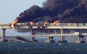 Black smoke billows from a fire on the Kerch bridge that links Crimea to Russia, after a truck exploded, near Kerch, on October 8, 2022. - Moscow announced on October 8, 2022 that a truck exploded igniting a huge fire and damaging the key Kerch bridge - built as Russia's sole land link with annexed Crimea - and vowed to find the perpetrators, without immediately blaming Ukraine.  (Photo by AFP)