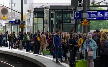 Rail passengers wait for a train on a platform at the main train station in Berlin on Octomer 8, 2022 following major disruption on the German railway network. - An act of "sabotage" targeting communications infrastructure was to blame for major disruption on the German railway network on Saturday, operator Deutsche Bahn said.
"Cable sabotage" was the cause of the breakdown, which led to a three-hour suspension of train services throughout northern Germany, a spokesman for the company told AFP. (Photo by John MACDOUGALL / AFP)