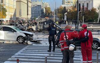This video grab taken from an AFPTV footage shows vehicles destroyed in Kyiv on October 10, 2022 as security and emergency forces work on the scene after several missile strikes were heard in the Ukrainian capital. (Photo by Arman SOLDIN / AFPTV / AFP) (Photo by ARMAN SOLDIN/AFPTV/AFP via Getty Images)