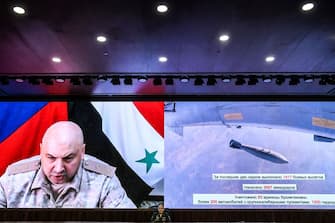 Russian Colonel-General Sergei Rudskoi (C) of the Russian military's General Staff and head of Russian troops in Syria Russian Colonel-General Sergei Surovikin (on screen) attend a briefing in the Russian Defence Ministry headquarters in Moscow on September 6, 2017. - Syria's army and allied fighters, backed by Russian air support, have been advancing towards Deir Ezzor on several fronts in recent weeks, and entered the Brigade 137 base on its western edge, in what Moscow hailed as a key "strategic victory". (Photo by Kirill KUDRYAVTSEV / AFP) (Photo by KIRILL KUDRYAVTSEV/AFP via Getty Images)