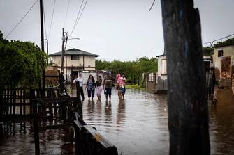 epa10233749 Inhabitants of Laguna de Las Peonias, in the Puerto Caballo sector, observe the floods in Maracaibo, Venezuela, 09 October 2022. At least 25 people died, among them two minors, and 52 are still missing as a result of the rains in the town of Tejerias, Aragua state, in the central zone of Venezuela, confirmed by the Executive Vice President, Delcy Rodriguez.  EPA/Henry Chirinos