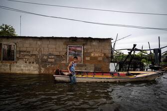 epa10233698 Inhabitants of Laguna de Las Peonias, in the Puerto Caballo sector, observe the floods in Maracaibo, Venezuela, 09 October 2022. At least 25 people died, among them two minors, and 52 are still missing as a result of the rains in the town of Tejerias, Aragua state, in the central zone of Venezuela, confirmed by the Executive Vice President, Delcy Rodriguez.  EPA/Henry Chirinos