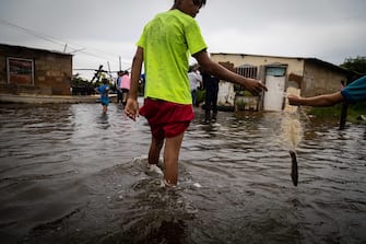 epa10233700 Inhabitants of Laguna de Las Peonias, in the Puerto Caballo sector, observe the floods in Maracaibo, Venezuela, 09 October 2022. At least 25 people died, among them two minors, and 52 are still missing as a result of the rains in the town of Tejerias, Aragua state, in the central zone of Venezuela, confirmed by the Executive Vice President, Delcy Rodriguez.  EPA/Henry Chirinos