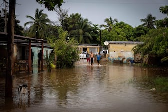 epa10233693 Inhabitants of Laguna de Las Peonias, in the Puerto Caballo sector, observe the floods in Maracaibo, Venezuela, 09 October 2022. At least 25 people died, among them two minors, and 52 are still missing as a result of the rains in the town of Tejerias, Aragua state, in the central zone of Venezuela, confirmed by the Executive Vice President, Delcy Rodriguez.  EPA/Henry Chirinos