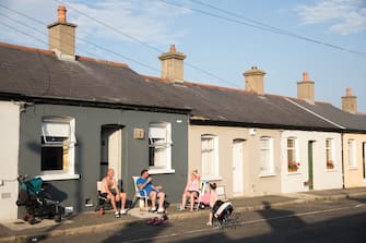 A family sits outside a terraced cottage residential property in Stoneybatter, Dublin, Ireland, on Monday, June 4, 2018. Companies are expanding in Dublin rather than the U.K. in a "silentÂ Brexit," according to Hibernia REIT Plc bossÂ Kevin Nowlan. Photographer: Jason Alden/Bloomberg via Getty Images