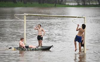epa10240421 Boys play at the flooded soccer pitch of Strathdale Park in Bendigo, Victoria, Australia, 13 October 2022. Victoria authorities issued a severe weather warning amid heavy rains.  EPA/JAMES ROSS AUSTRALIA AND NEW ZEALAND OUT