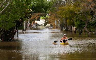 epa10242586 A man is seen canoeing along flood waters in Maribyrnong, Melbourne, Australia, 14 October 2022. Victorian residents have been told to move to higher ground as rain continue to pummel vast swathes of the state, causing flooding and thousands of power outages.  EPA/JAMES ROSS  AUSTRALIA AND NEW ZEALAND OUT