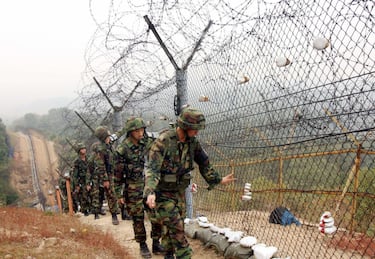 PAJU, REPUBLIC OF KOREA:  South Korean soldiers patrol along the barbed wire fence near an observation point, on the southern side of the Demilitarized Zone (DMZ) dividing North and South Korea, in Paju, 09 October 2006. North Korea announced 09 October it conducted a nuclear weapons test in defiance of worldwide appeals and threats of sanctions, sparking a furious reaction from Seoul which called it an "unpardonable provocation."   AFP PHOTO/SHIN WON-GUN  (Photo credit should read SHIN WON-GUN/AFP via Getty Images)