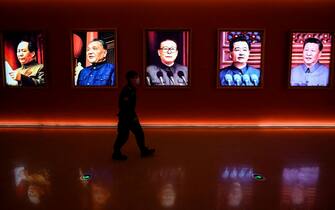 TOPSHOT - A man walks past portraits of (L to R) late Chinese chairman Mao Zedong and former Chinese leaders Deng Xiaoping, Jiang Zemin, Hu Jintao and current president Xi Jinping at Yanan Revolutionary Memorial Hall in Yan'an city, in Chinas northwest Shaanxi province on October 15, 2022, one day ahead of the 20th Communist Party Congress. (Photo by Jade Gao / AFP) (Photo by JADE GAO/AFP via Getty Images)