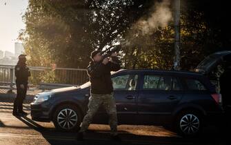 A police officer fires at a flying drone following attacks in Kyiv on October 17, 2022, amid the Russian invasion of Ukraine. (Photo by Yasuyoshi CHIBA / AFP) (Photo by YASUYOSHI CHIBA/AFP via Getty Images)