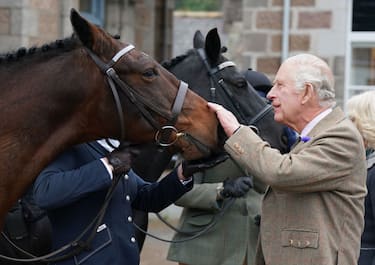 BALLATER, SCOTLAND - OCTOBER 11: King Charles III feeds carrots to horses as he attends a reception to thank the community of Aberdeenshire for their organisation and support following the death of Queen Elizabeth II at Station Square, the Victoria & Albert Halls, on 11th October, 2022 in Ballater, Scotland. (Photo Andrew Milligan - WPA Pool/Getty Images)