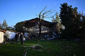 Local residents stand next to a damaged building in Bihucourt, northern France, on October 24, 2022 after a tornado hit the region. (Photo by Sameer Al-Doumy / AFP) (Photo by SAMEER AL-DOUMY/AFP via Getty Images)