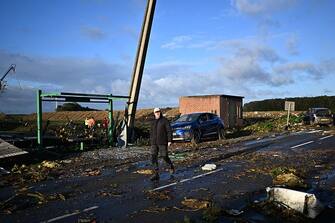 A local resident walks past a street full of debris in Bihucourt, northern France, on October 24, 2022 after a tornado hit the region. (Photo by Sameer Al-Doumy / AFP) (Photo by SAMEER AL-DOUMY/AFP via Getty Images)