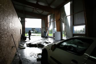 Owners of a automobile workshop look at damages in Beuzeville, northern France on October 24, 2022, after a tornado hit the region. (Photo by Lou BENOIST / AFP) (Photo by LOU BENOIST/AFP via Getty Images)