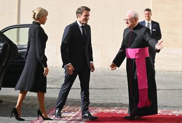French President Emmanuel Macron (C) and his wife Brigitte Macron are welcomed by Italian priest and writer Monsignor Leonardo Sapienza (R) as they arrive for a private audience with Pope Francis, at the San Damaso courtyard in Vatican City, 24 October 2022.  ANSA/ETTORE FERRARI