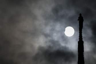 MILAN, ITALY - OCTOBER 25: A partial solar eclipse is seen behind the Duomo Cathedral spiers in Milan, Italy on October 25, 2022 (Photo by Piero Cruciatti / Anadolu Agency via Getty Images)
