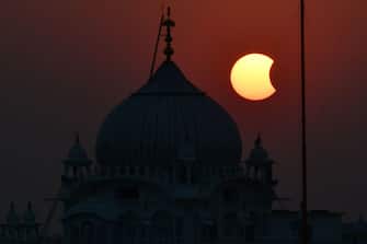 TOPSHOT - The moon (R) partially obscures the sun during a partial solar eclipse visible from Patna on October 25, 2022. (Photo by Sachin KUMAR / AFP) (Photo by SACHIN KUMAR / AFP via Getty Images)