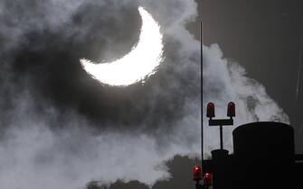 epa10264963 Smoke rises from chimney of a gas boiler house during partial solar eclipse in Moscow, 25 October 2022. From Moscow the sun will appear about 70 percent eclipsed as the moon passes between the Earth and the sun, obscuring the sun from view.  EPA/MAXIM SHIPENKOV