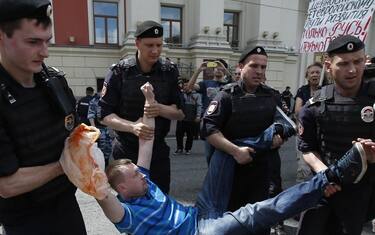 Police officers detain Nikolai Alexeyev (C), an activist of the LGBT (lesbian, gay, bisexual, and transgender) community, who was trying to participate in a parade in front of the Moscow's mayor office building in Moscow, Russia, 30 May 2015. ANSA/SERGEI ILNITSKY