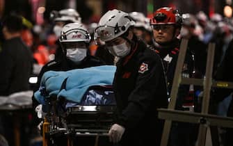 A victim of a Halloween crush, which left at least 120 people dead, is transported on a stretcher in the district of Itaewon in Seoul on October 30, 2022. - At least 120 people were killed on October 29 and some 100 were injured in a stampede in central Seoul when thousands crowded into narrow streets to celebrate Halloween, officials said. (Photo by Anthony WALLACE / AFP) (Photo by ANTHONY WALLACE/AFP via Getty Images)