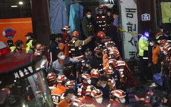 SEOUL, SOUTH KOREA - OCTOBER 30: Emergency services treat injured people after a stampede on October 30, 2022 in Seoul, South Korea. At least 50 people were reported to be receiving CPR after suffering from cardiac arrest in Seoul's Itaewon area as huge crowds of people stampeded at Halloween parties, according to authorities. (Photo by Chung Sung-Jun/Getty Images)