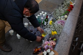epa10274762 A man lays flowers where a deadly stampede took place the previous day in Seoul, South Korea, 30 October 2022. According to the National Fire Agency, at least 151 people were killed and 82 were injured in the stampede on 29 October as a large crowd came to celebrate Halloween.  EPA/JEON HEON-KYUN