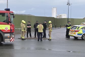 epa10275017 Police officers and a fire crew attends the scene of a suspected attack on a migrant processing centre in Dover, Britain, 30 October 2022. The suspected attacker was believed to have thrown petrol bombs at the migrant centre before taking his own life, according to witnesses.  EPA/STUART BROCK